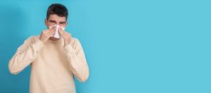 Man blowing his nose, seasonal allergies
